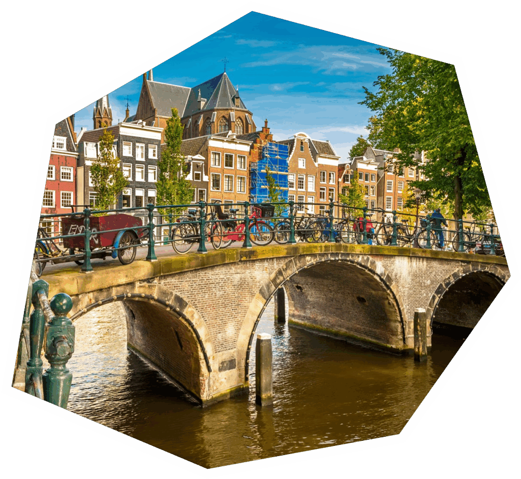 A bridge in Amsterdam with bicycles parked and colourful houses in the background
